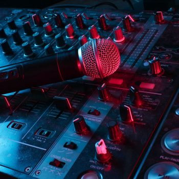 Night club, nightlife concept. Disco. Microphone on DJ remote. Neon red blue light Night club, nightlife concept. Disco. Microphone on DJ remote. Neon red blue light